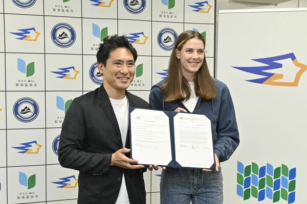 フォトセッションに臨む渡辺市長（左）とマフチフ選手＝14日午後、都内