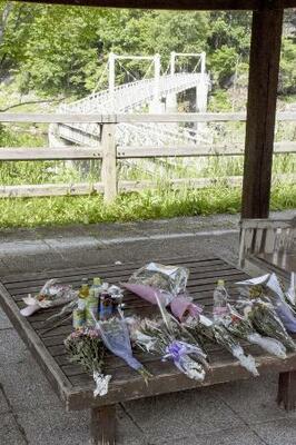 北海道留萌市の女子高生の殺害現場となった、旭川市の神居古潭地区にあるつり橋付近に手向けられた花束=2024年