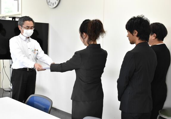 新型コロナウイルスワクチンによる健康被害の周知などを求め、県感染症対策課長に要望書を手渡す遺族＝21日午前、県庁北別館