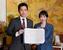 　署名した連立政権合意書を報道陣に示す自民党の高市総裁（右）と日本維新の会の吉村代表＝２０日午後、国会