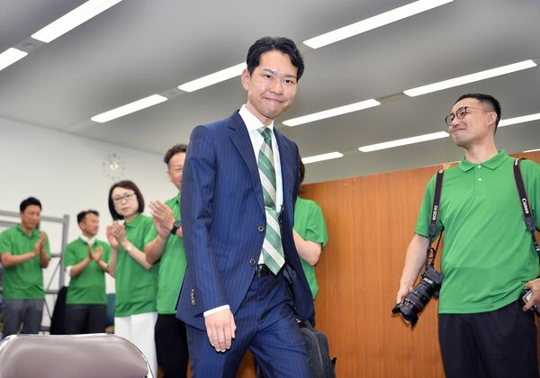 会見場に入り笑顔を見せる毛塚幹人氏＝11日午後、県庁記者クラブ
