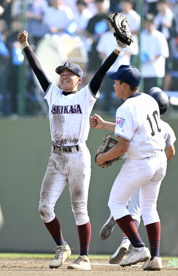 ９回、投ゴロのアウトで勝利を決め、笑顔で両手を突き上げる足利の一塁手・中田（左）＝エイジェック、森田大地撮影