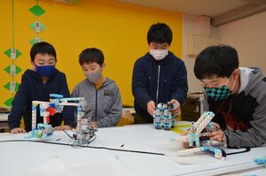 ロボットがプログラム通りに動くか確認する子どもたち