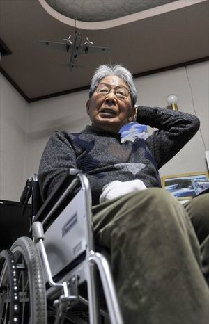 車いす生活を余儀なくされている高石近夫さん。居間の天井に自らが搭乗した「一式陸上攻撃機」の模型がつるされている=10日、小山市内