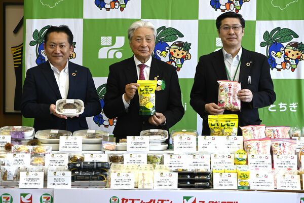 県産食材を使用した商品を手にする福田知事（中央）ら＝16日午前、県庁
