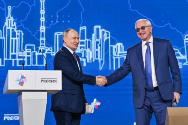 　ロシア産業企業家同盟の年次総会で握手するショーヒン会長（右）とプーチン大統領＝２６日、モスクワ（タス＝共同）