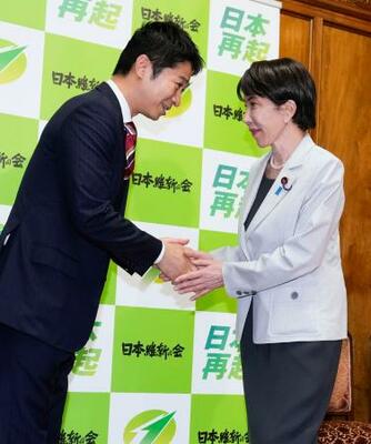 　２０２６年度補正予算案が衆院を通過し、あいさつ回りで日本維新の会の藤田共同代表（左）と握手する高市首相＝４日午後、国会