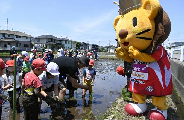 ライトくんの応援を受け、田植えをする子どもたち