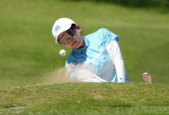 第2ラウンド、18番でバンカーショットを放つ勝みなみ。通算13アンダーで3位に浮上した=ワールウインドGC(共同)