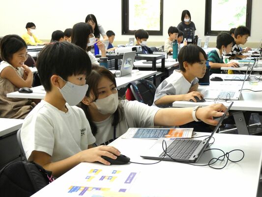 プログラムを組んで動く絵を作る児童ら