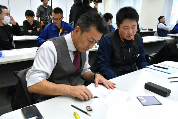 講習会で習った内容を生かして似顔絵を描く参加者ら＝９日午後、県警本部