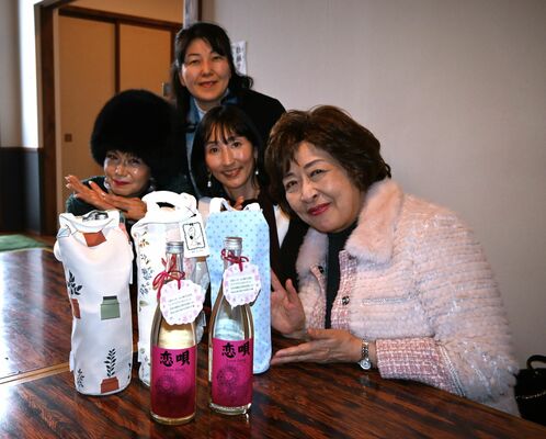 クラブ発起人の安達会長（右）、川田さん（左）。手前は記念品としても配ったオリジナルの日本酒「恋唄」
