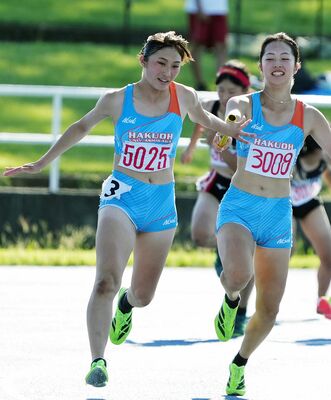 女子４００メートルリレー決勝　白鴎足利の第３走者・厚木（右）からバトンを受け取る第４走者・加藤＝県総合運動公園第２陸上競技場、橋本裕太撮影