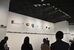 「今日の彫刻」が水平展示された上にある「トルソ、或いはチャーハン」。冨井さん（写真奥）は、何となく集まった、残ったものを再構築した“賄い”みたいな作品だと説明する