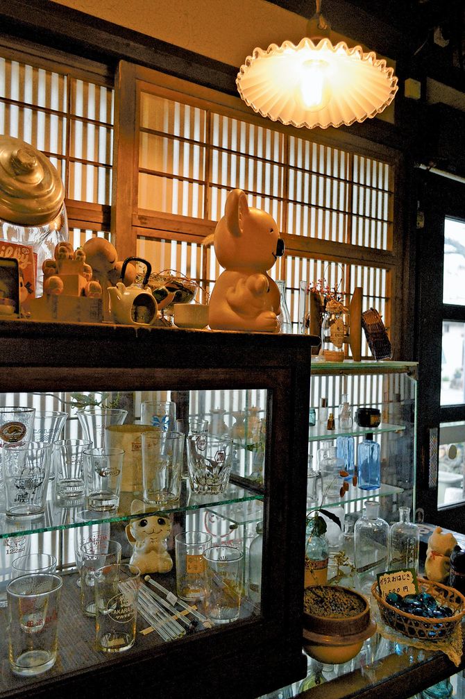 千本格子の格子戸にアンティークの電笠、レトロなガラスコップや薬瓶が並ぶ店内