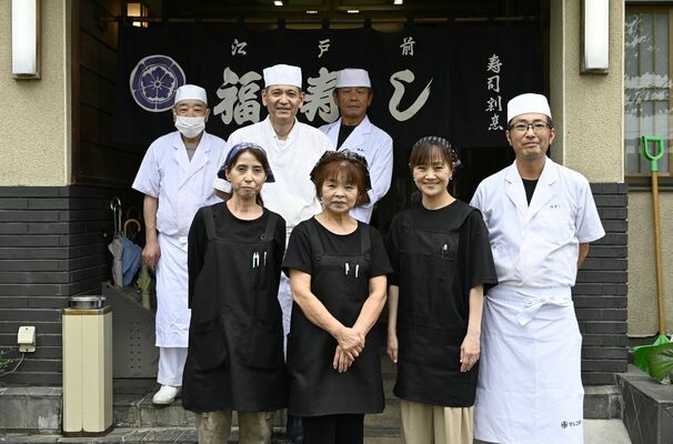 店長の小柳武さん（前列右）と妻の理恵さん（同右から２人目）ら