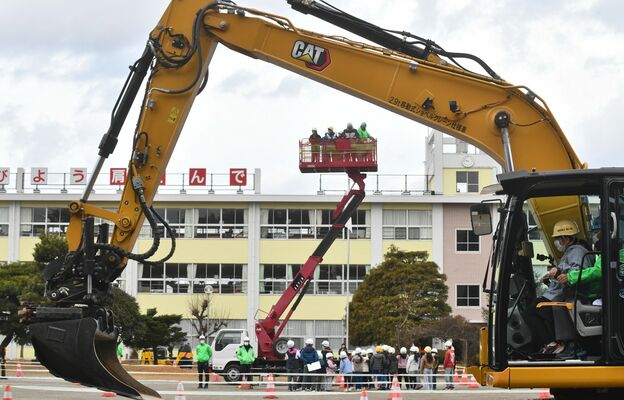 重機の操作や高所作業車の搭乗体験を行う児童たち