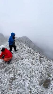 機体が見つかった熊本県・阿蘇山の中岳火口付近で活動する捜索隊=21日(熊本県警提供)