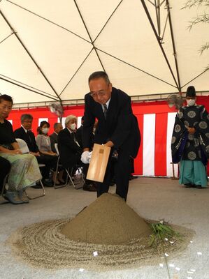 起工式でくわ入れを行う巴山理事長
