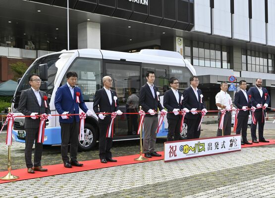 ＥＶバスの前でテープカットに臨む関係者