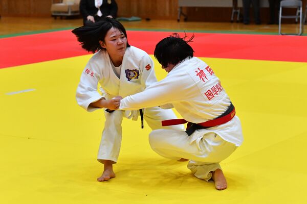 女子無差別級決勝　大外刈りを仕掛ける足大女の小堀（左）＝ユウケイ武道館