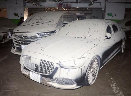駐車場の地下2階で水没し、乾いて白くなった泥に覆われた車=19日午後、三重県四日市市