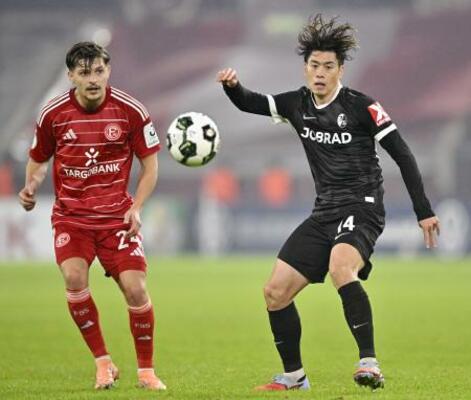 　デュッセルドルフ戦で競り合うフライブルクの鈴木唯（右）＝デュッセルドルフ（共同）