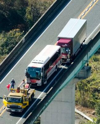観光バス(中央)に大型トラックが追突した徳島自動車道の事故現場=18日午後1時22分、徳島県美馬市(共同通信社ヘリから)