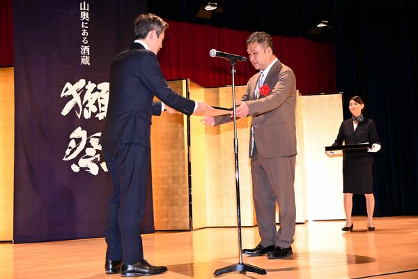 準グランプリの表彰状を受け取る鈴木さん（中央）＝20日午前、東京都内