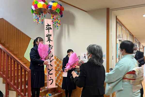 くす玉で祝われる卒業生ら