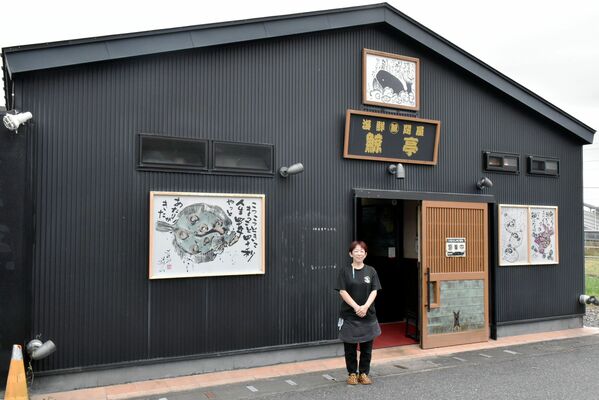 クジラのように黒い店舗の外観と店員