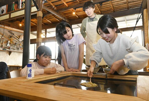 基地ひるねで池田さん（中央後方）ともんじ焼き作りを楽しむ小学生たち