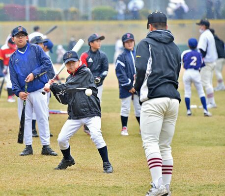 交流会で作新高の選手（手前）にバッティングを教わる子どもたち＝小山運動公園野球場