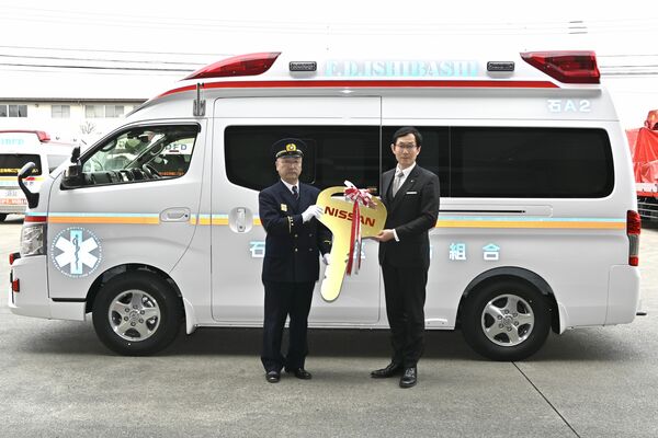 坂村市長（右）からレプリカキーを受け取る鯉沼消防長