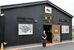 クジラのように黒い店舗の外観と店員
