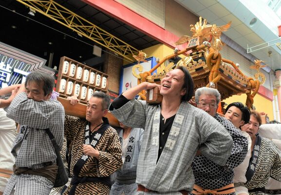 威勢良くオリオン通りを渡御する市場神輿
