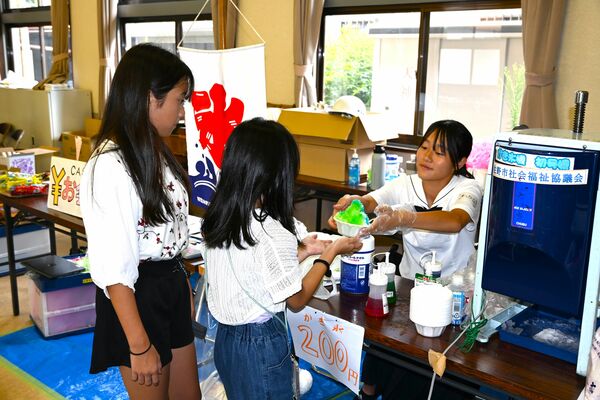 作ったかき氷を子どもに手渡す佐野高の生徒