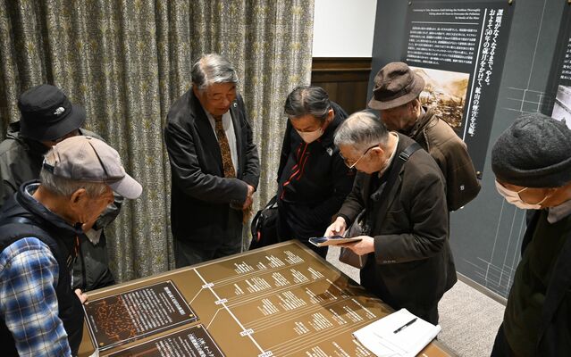 足尾銅山記念館で鉱害の年表に関する表記について議論する同盟会メンバーら