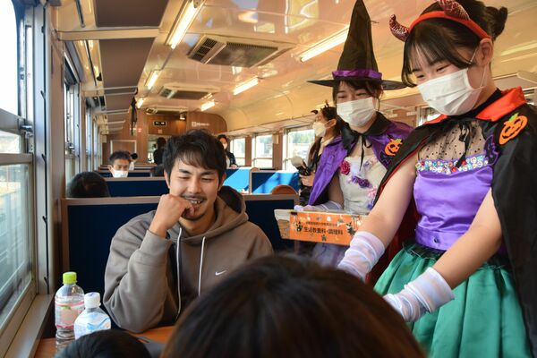 自作のドレスでお菓子を渡す生徒ら