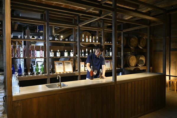 蒸留所内で原酒のブレンドを試みる西堀専務=小山市