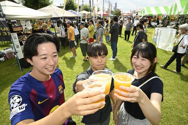 クラフトビールを手に笑顔を見せる来場者たち＝28日午前11時40分、下野市役所