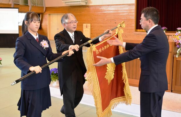 校旗を返納する斎藤校長（中央）