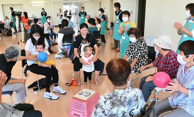 乳幼児とボール遊びをして触れ合う地域住民ら