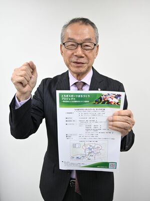 キックオフ会のチラシを掲げ、意気込む新見常務理事