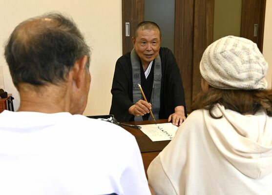 檀家（だんか）の夫婦と話し合いながら戒名を決める林住職（奥）