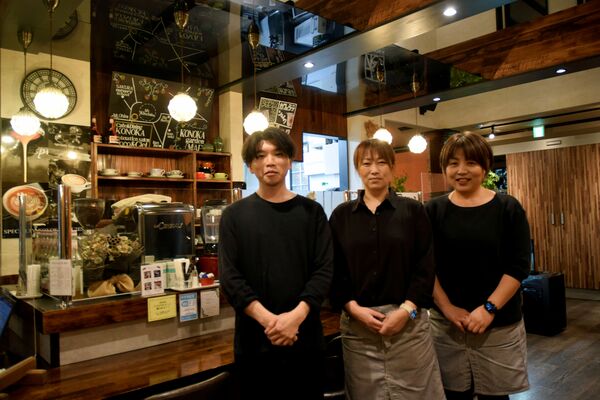 木目調で整えられた店内に立つ今成さん（中央）ら
