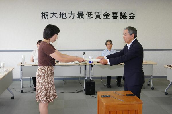 最低賃金改定に関する答申書を栃木労働局の川口秀人局長（右）に手渡す栃木地方最低賃金審議会の杉田明子会長＝５日午後、宇都宮市