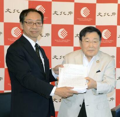 文化庁の松坂浩史審議官(左)に署名を提出する「関西・歌舞伎を愛する会」の堀井良殷代表世話人=10日午後、京都市上京区