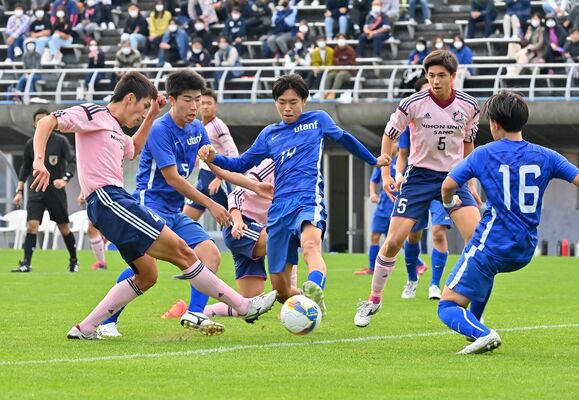 前半３８分、宇短大付のＤＦ塚原（中央）が相手のシュートを防ぐ＝県グリーンスタジアム