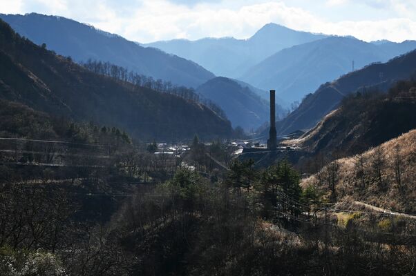 製錬所跡の煙突と周囲の山々。かつては木々のないはげ山だった＝２０２２年12月中旬、日光市足尾町、銅親水公園駐車場